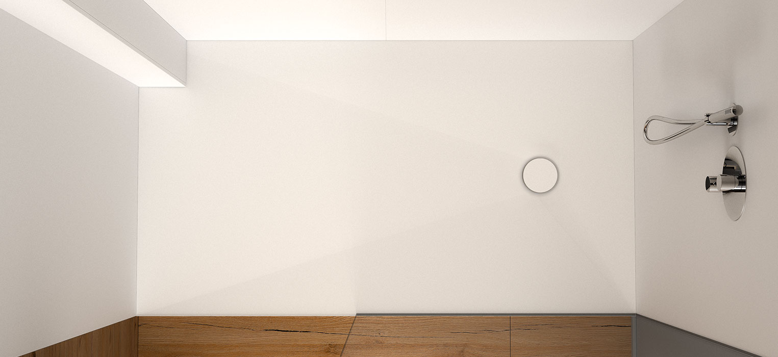Draufsicht auf einen minimalistischen Duschbereich mit weißen Wänden, einem runden Ablauf auf dem Boden, silbernen Duscharmaturen an der rechten Wand und einem Streifen Holzboden am Rand.
