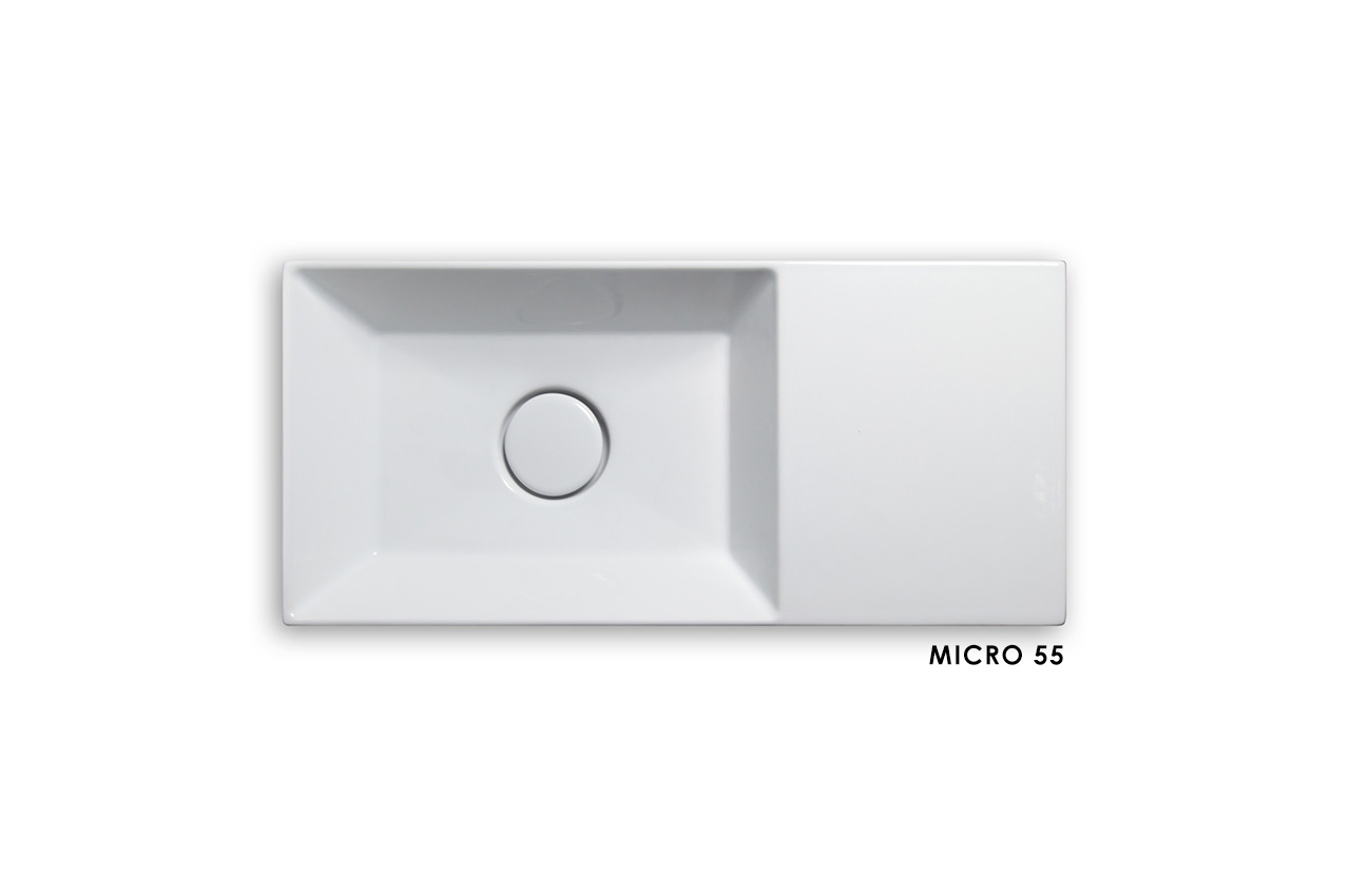 Rechteckiges weißes Keramikspülbecken mit zentriertem Abflussloch und einer flachen Oberfläche auf der rechten Seite. Der Schriftzug MICRO 55 erscheint in kleiner schwarzer Schrift in der rechten unteren Ecke.