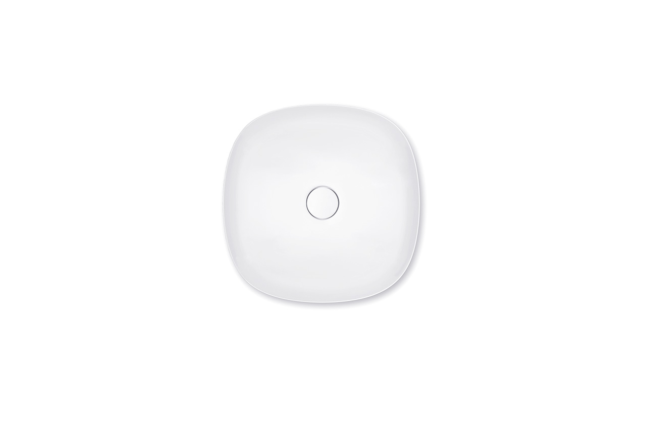 Draufsicht auf ein modernes, weißes, quadratisches Waschbecken mit abgerundeten Ecken und einem zentralen Abflussloch vor einem schlichten weißen Hintergrund.